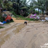 Kid playing in front of piles of litter